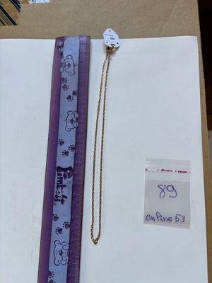 a picture of a ruler and a necklace in a box