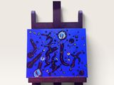 tableau violet et bleu posé sur un chevalet en bois contre un mur blanc