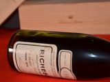 a bottle of wine sitting on a table next to a knife