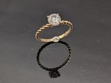 une photo d'une bague en diamant posée sur un fond noir
