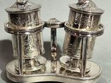 a silver salt and pepper shaker set on a stand
