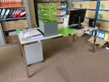 a desk with a computer on it in the middle of a room
