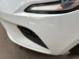 a close up of a white car ' s front bumper