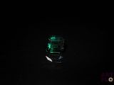 une image représentant une bouteille contenant un liquide vert dans l'obscurité