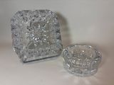 a glass ashtray and a glass ashtray sitting on a table