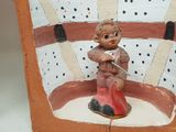 a small figurine of a boy sitting on a bench