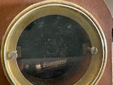 a close up of a clock on a wooden table