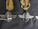 three badges of various sizes and shapes are hanging on a wall