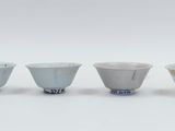 three white and blue bowls sitting next to each other on a white surface