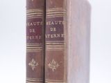 two old books sitting on top of each other on a white surface