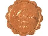 a small copper medal with the name of a woman