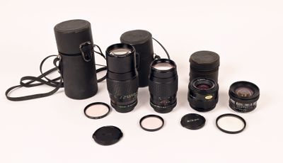 de nombreux types d'appareils photo et d'objectifs sur une surface blanche