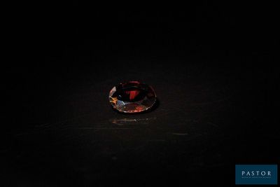 gros plan d'un diamant rouge sur une surface noire