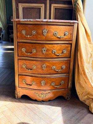 une commode qui se trouve dans un coin de la pièce