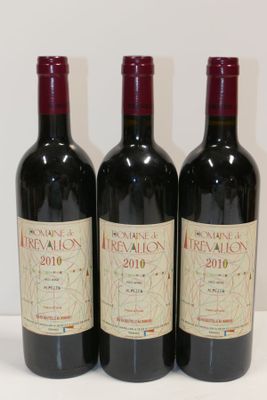 trois bouteilles de vin rouge sont alignées sur une table