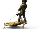 bronze figurine of a boy on a surfboard with a leash