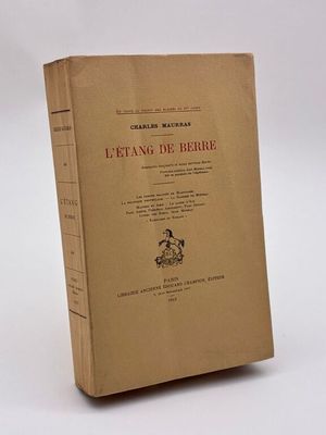 un vieux livre posé sur une table à côté d'un fond blanc