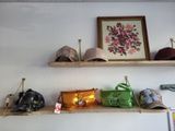 many hats and purses on a shelf in a room