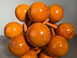 a wooden sculpture of a bunch of balls on a table