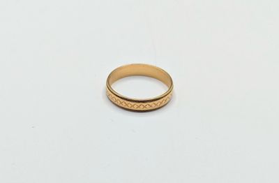 gros plan d'une bague en or sur une surface blanche