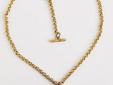 un collier plaqué or avec une boule suspendue à une chaîne