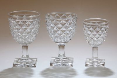 trois verres à pied en verre transparent posés sur une table blanche