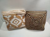two brown and white pillows sitting on top of a white table