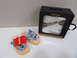 une paire de chaussures de bébé et une boîte posées sur une table