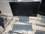 two monitors and a keyboard sitting on a pallet