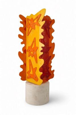 a yellow and orange sculpture with stars on top of it