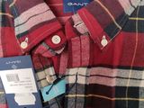 a close up of a red and black plaid shirt with a tag on it