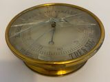 une horloge dorée posée sur une table blanche, sur fond blanc