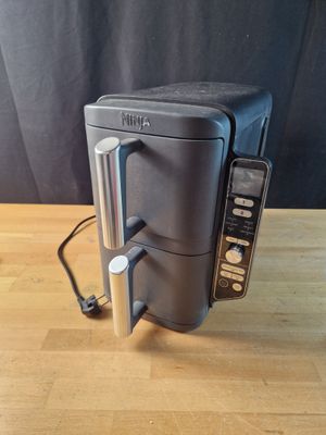 une photo d'un grille-pain posé sur une table, avec une télécommande à côté