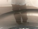 a reflection of a person standing on a tire