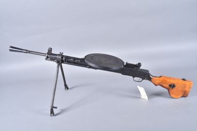 an orange and black toy gun on a stand with a white background