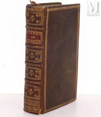 an old book sitting on top of a table next to a white wall