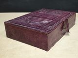 purple leather box on a wooden table with a black background