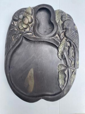 une assiette en argent ornée d'un motif représentant un oiseau et une fleur
