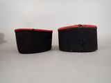 pair of black and red boxes sitting on top of a white table