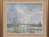 une peinture à l'huile représentant des oiseaux survolant un lac, dans un cadre doré