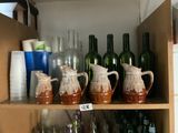 de nombreuses bouteilles et vases posés sur une étagère dans un meuble
