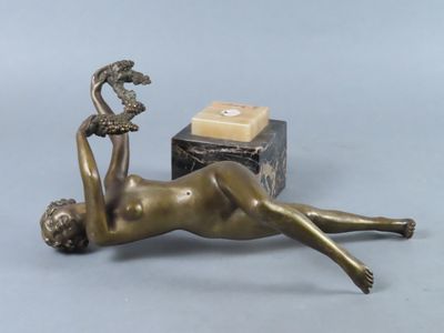 bronze statue of a woman laying on her back with a box in the background