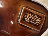 a close up of a brown vase with a label on it