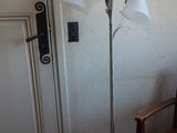 une lampe qui se trouve à côté d'une chaise dans une pièce