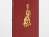 un livre rouge avec un logo doré sur la couverture