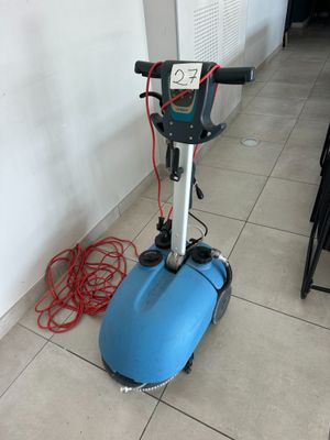 a blue machine that is on the floor next to a wall