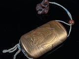 a gold case with a flower on it sitting on a table