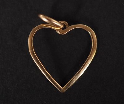 un pendentif en forme de cœur doré sur fond noir