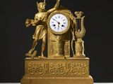 une horloge en or surmontée d'une statue