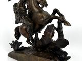 bronze statue of a man on a horse with a gun on his back